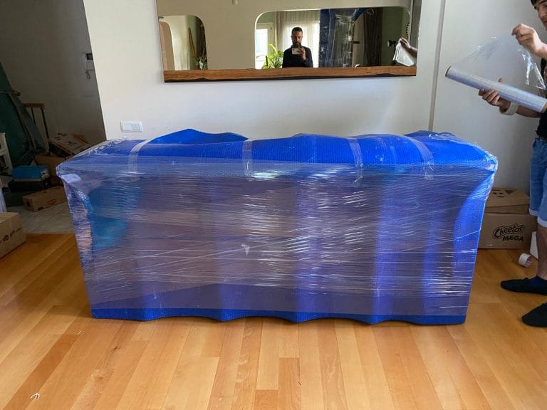 Florya nakliyat hizmeti: Eşyaların kapı girişlerinde çizilmelere karşı korunması için profesyonel paketlenmesi.